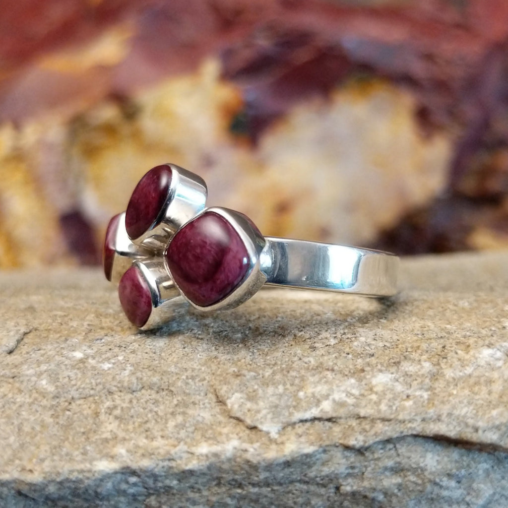 Four purple spiny oyster shells clustered together on a thin sterling silver band.