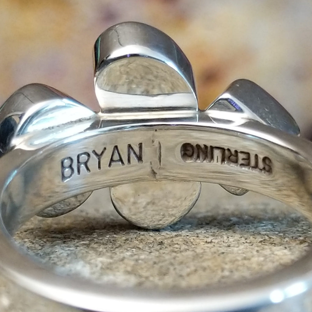 The artisan's signature is stamped on the underside of the band.