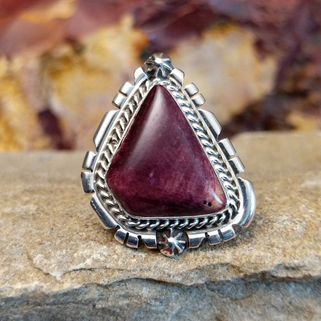 Triangular purple spiny oyster shell with intricate incised and twisted rope setting.