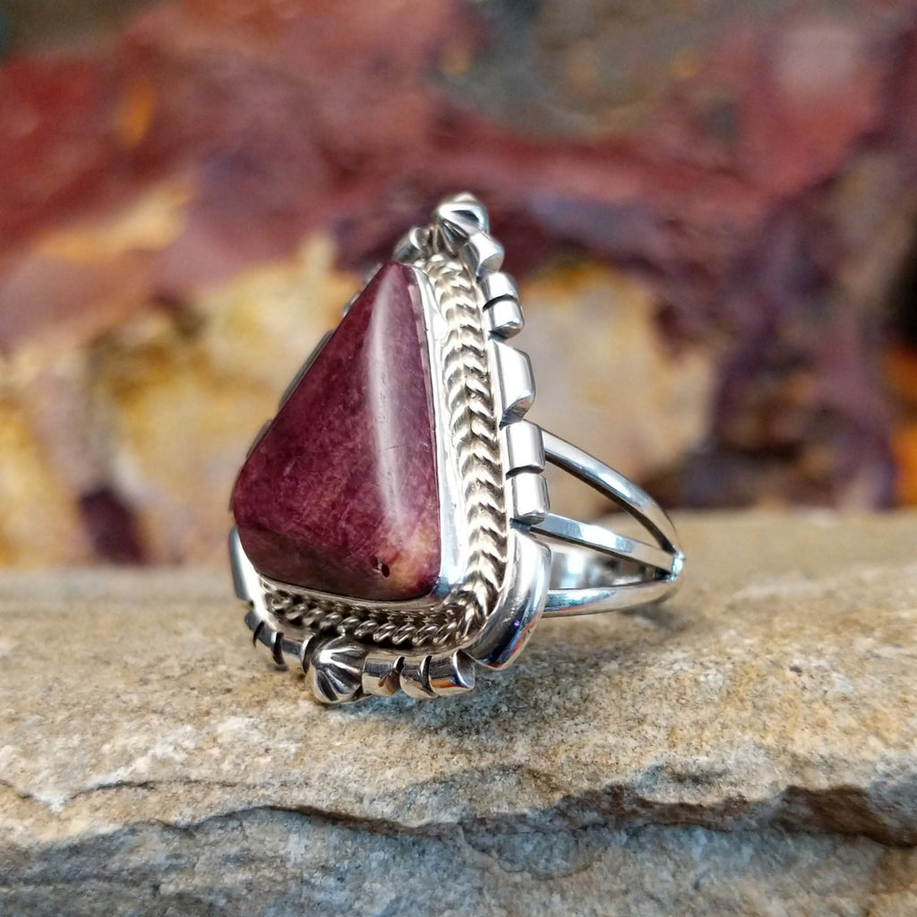 Triangular purple spiny oyster shell with intricate incised and twisted rope setting.