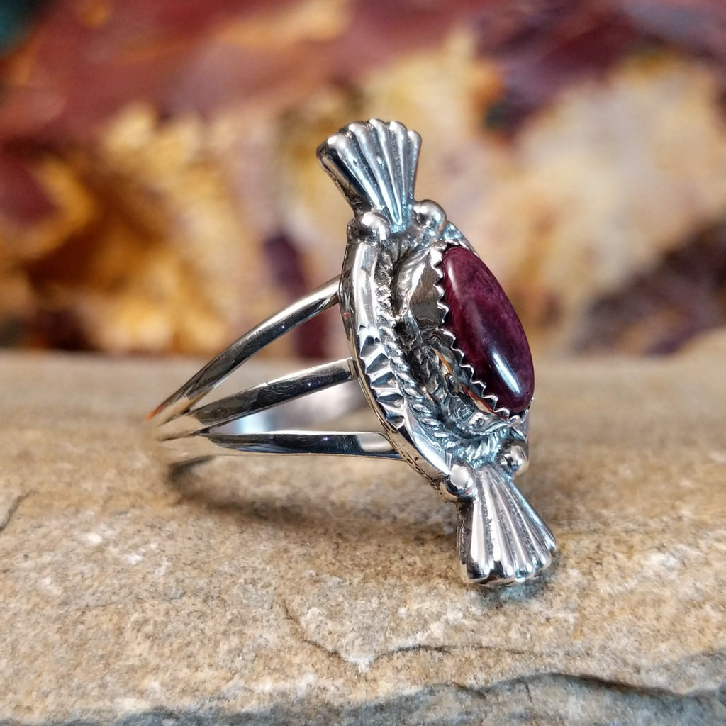 Purple spiny oyster shell set in a notched bezel with twisted rope and fan detailing on the frame.