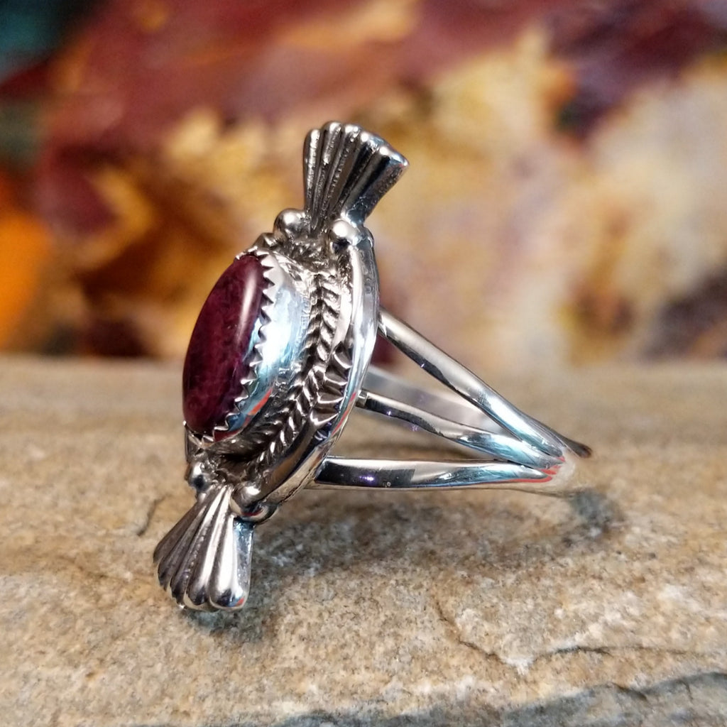 Purple spiny oyster shell set in a notched bezel with twisted rope and fan detailing on the frame.