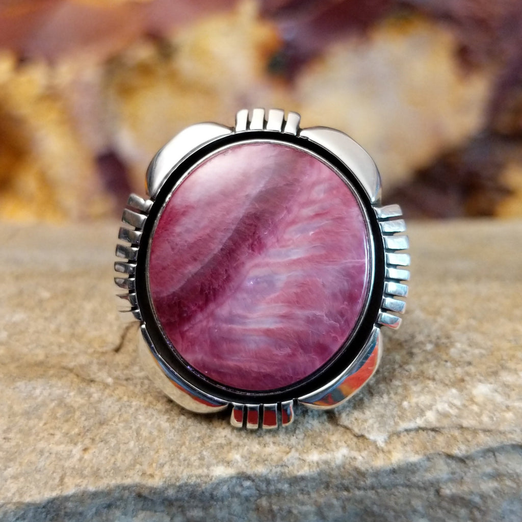 Round purple spiny oyster shell set in a shadowbox setting with incised and scalloped edges.