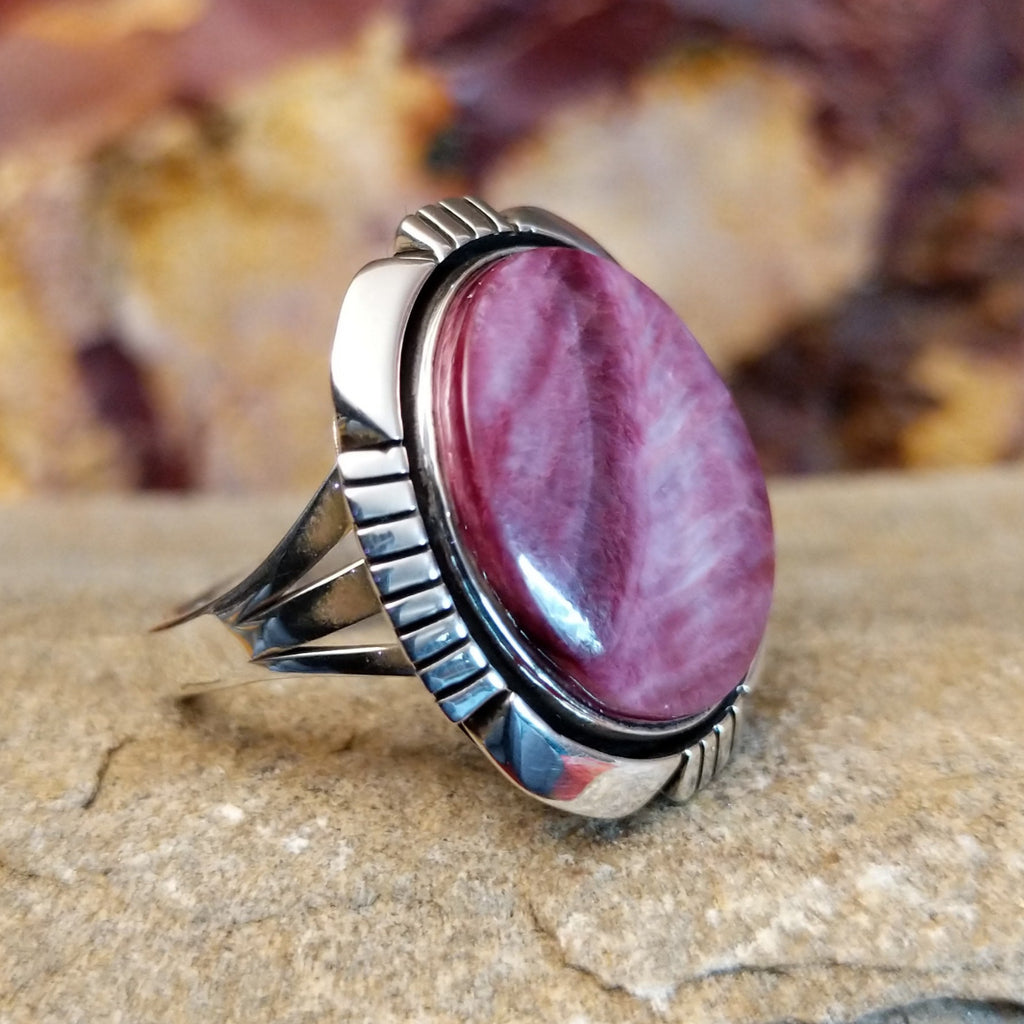 Round purple spiny oyster shell set in a shadowbox setting with incised and scalloped edges.