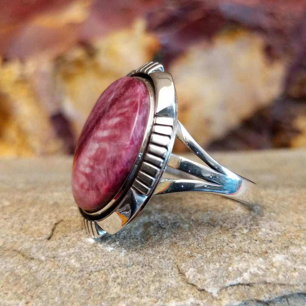 Round purple spiny oyster shell set in a shadowbox setting with incised and scalloped edges.