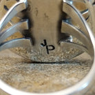 The initials are stamped onto the underside of the setting.