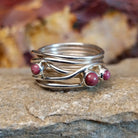 Three small purple spiny oyster shells set on a twisted, layered band.