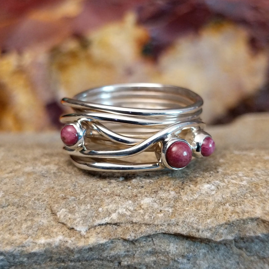 Three small purple spiny oyster shells set on a twisted, layered band.
