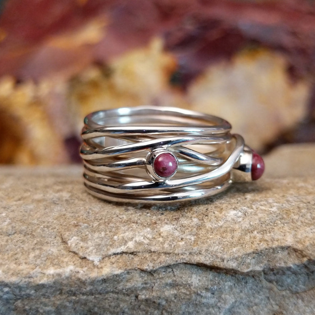 Three small purple spiny oyster shells set on a twisted, layered band.