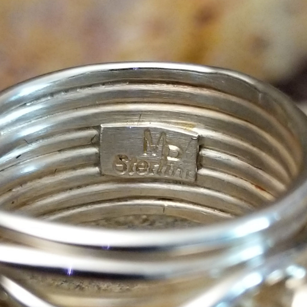 The artisan's stamp is found on the interior of the band.