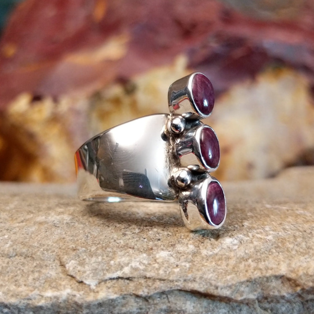 Three small purple spiny oyster shells set on the polished sterling silver band.