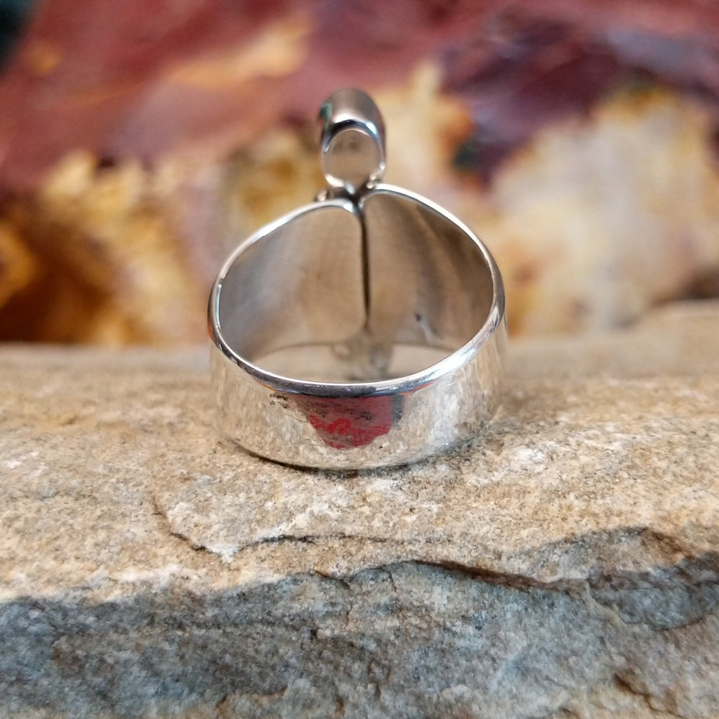 Tapered, polished silver band of the ring.