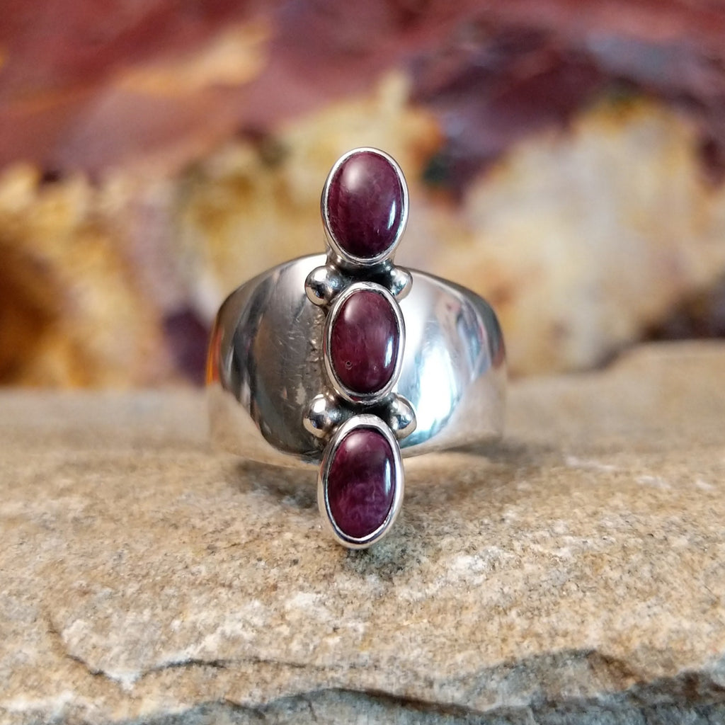 Three small purple spiny oyster shells set on the polished sterling silver band.