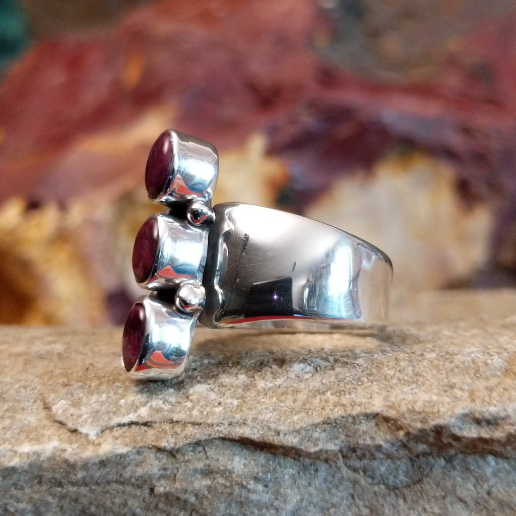 Three small purple spiny oyster shells set on the polished sterling silver band.