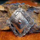 Diamond shaped sterling silver pendant with sun ray motif.