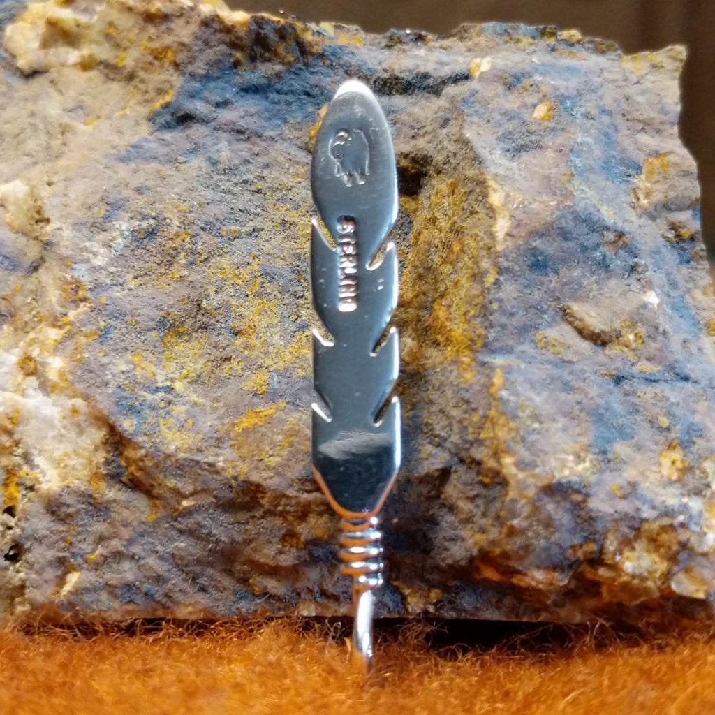 The authentication stamp is found on the back of the feather.