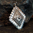 Stamped sterling silver pendant with scalloped edges and various designs.