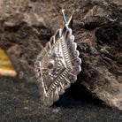 Stamped sterling silver pendant with scalloped edges and various designs.