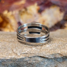 The sterling silver tri-band tapers toward the center.