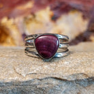Triangular purple spiny oyster shell with a tri-band featuring ornate stamping along it.