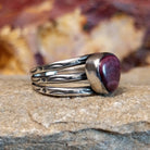 Triangular purple spiny oyster shell with a tri-band featuring ornate stamping along it.