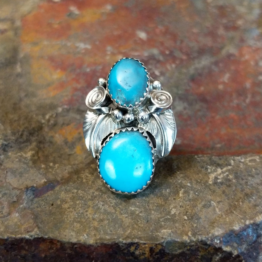 Turquoise feather ring displays two turquoise stones set in an engraved sterling silver setting.