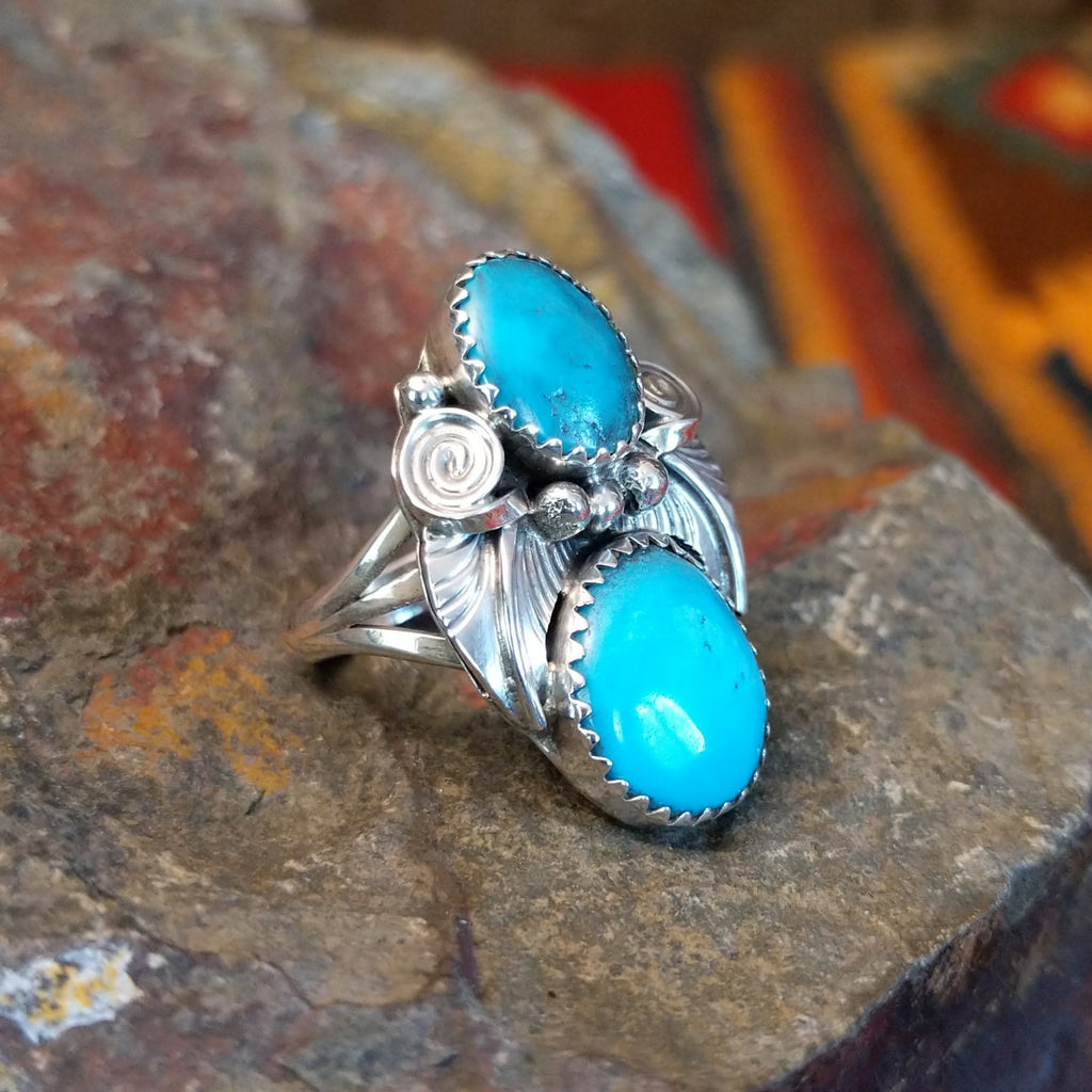 Turquoise feather ring displays two turquoise stones set in an engraved sterling silver setting.