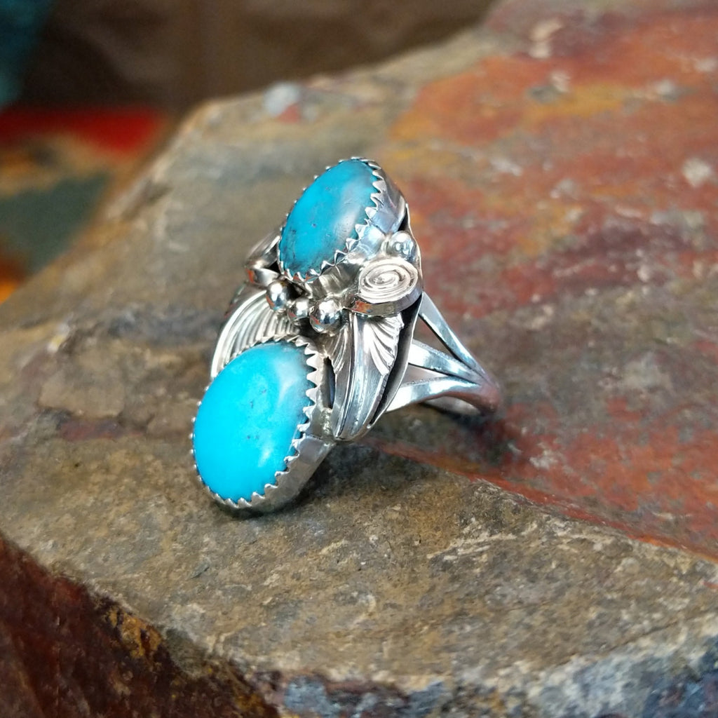 Turquoise feather ring displays two turquoise stones set in an engraved sterling silver setting.