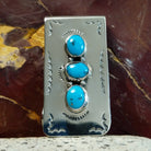 Navajo made turquoise money clip with three turquoise stones and silver detailing.