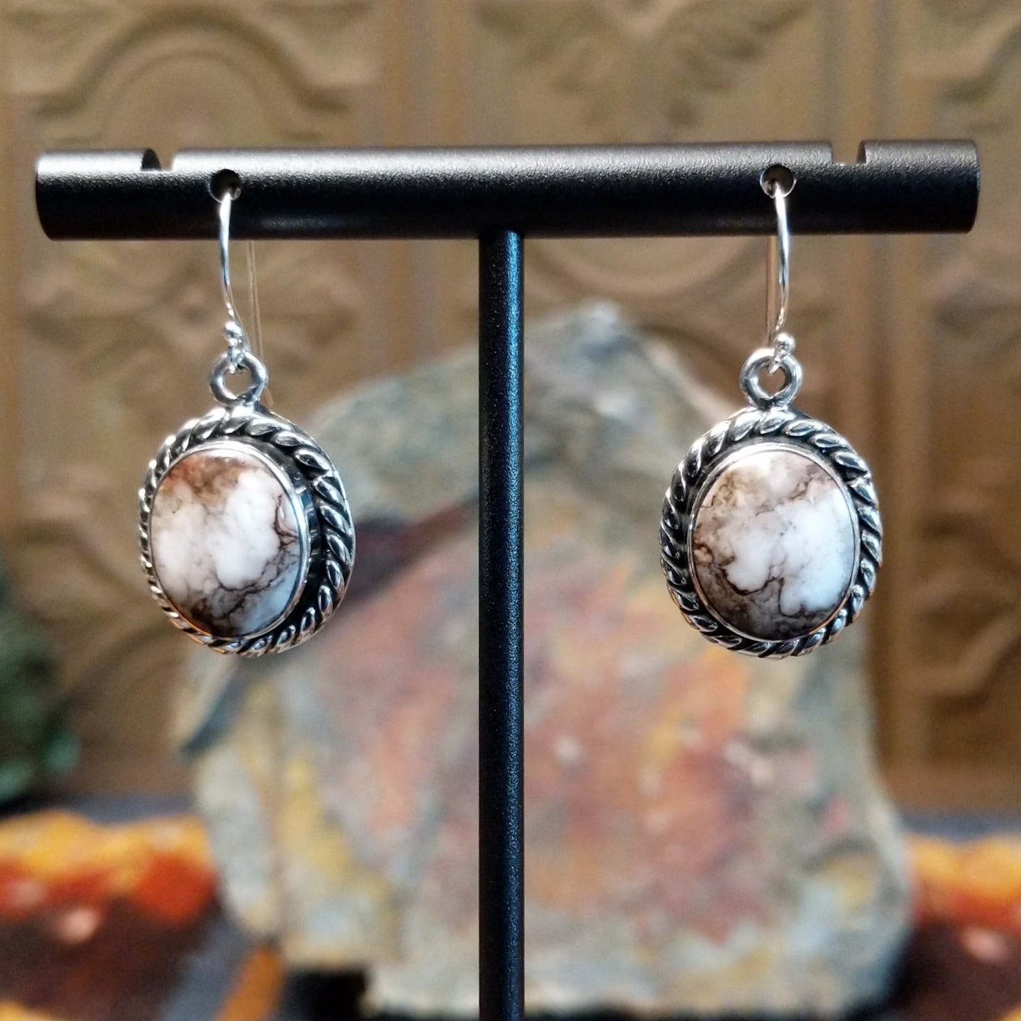 Round wild horse stones set in twisted rope silver bezels of the dangle earrings.