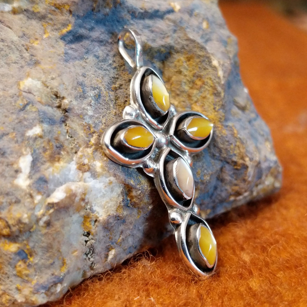 Yellow mussel shell set in sterling silver shadowbox settings shaped as a cross.