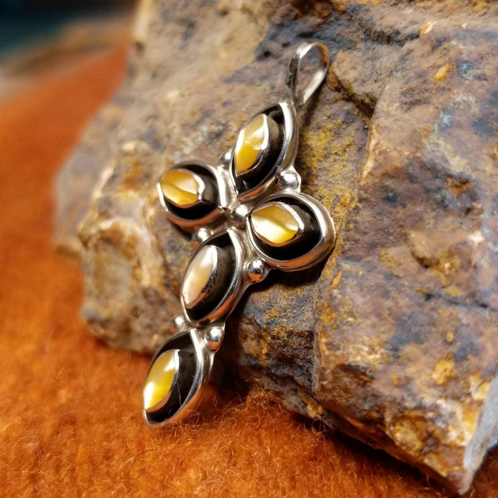 Yellow mussel shell set in sterling silver shadowbox settings shaped as a cross.