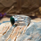 Sterling silver ring with malachite set in the raised, round bezel and silver strands making up the band.