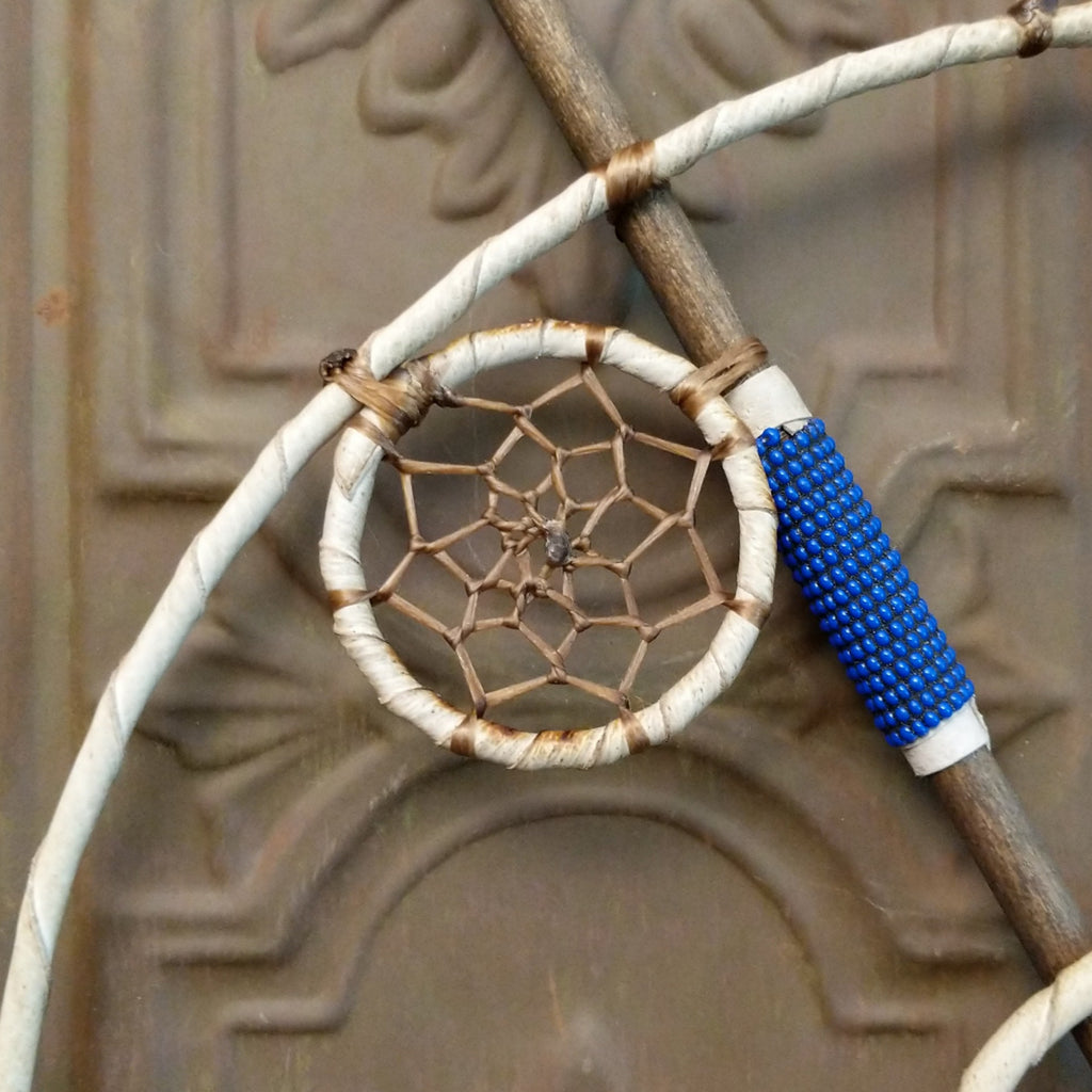 Mandela made from wood, with arrows, beads, feather, and buffalo bone set with different meanings.