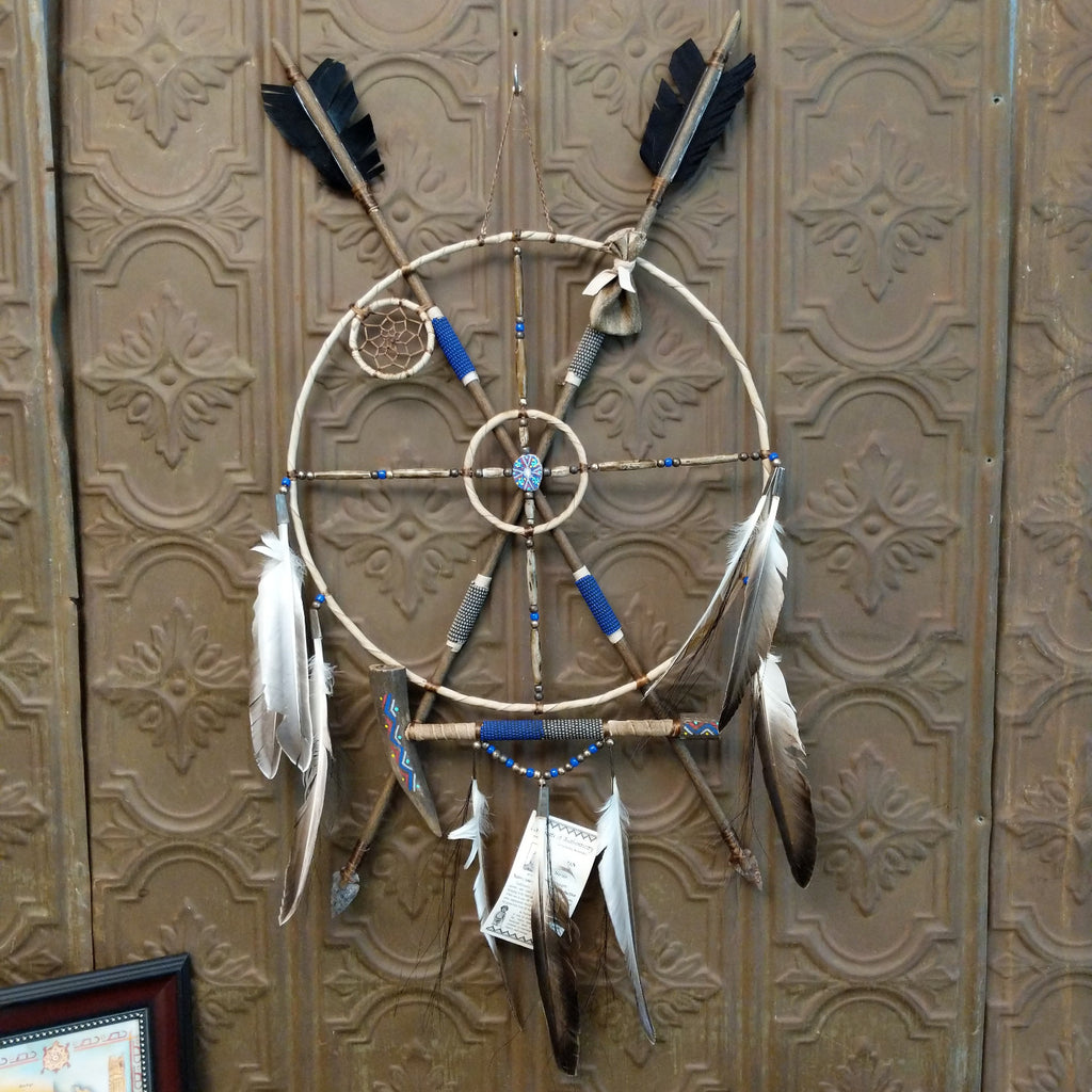 Mandela made from wood, with arrows, beads, feather, and buffalo bone set with different meanings.