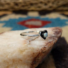 Navajo manmade opal heart ring, featuring a heart-shaped shimmering opal with vibrant flashes of color set in a handcrafted sterling silver band.  Side view.