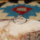 Navajo manmade opal heart ring, featuring a heart-shaped shimmering opal with vibrant flashes of color set in a handcrafted sterling silver band.  Underside view.