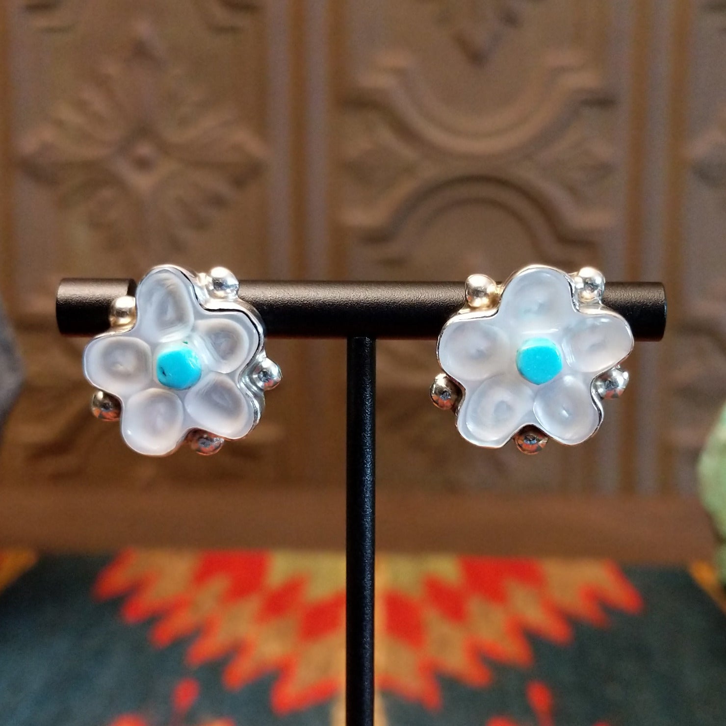 Sterling silver flower earrings with mother of pearl petals and turquoise centerpieces.