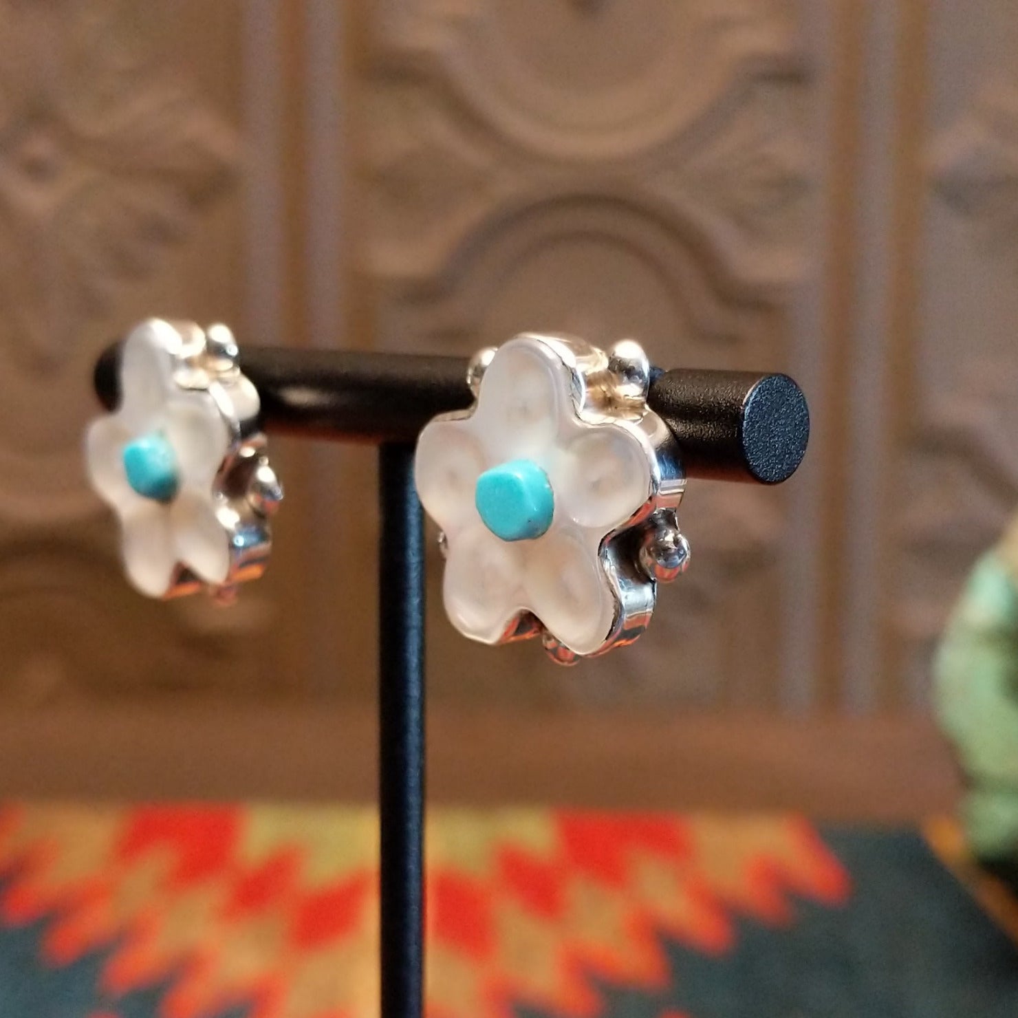 Sterling silver flower earrings with mother of pearl petals and turquoise centerpieces.