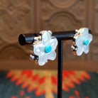 Sterling silver flower earrings with mother of pearl petals and turquoise centerpieces.