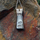 Navajo multistone cobblestone inlay pendant by J.Y. featuring turquoise, lapis, black matrix turquoise, white, and green stone inlay in a geometric sterling silver design; artisan and Sterling Silver stamp.