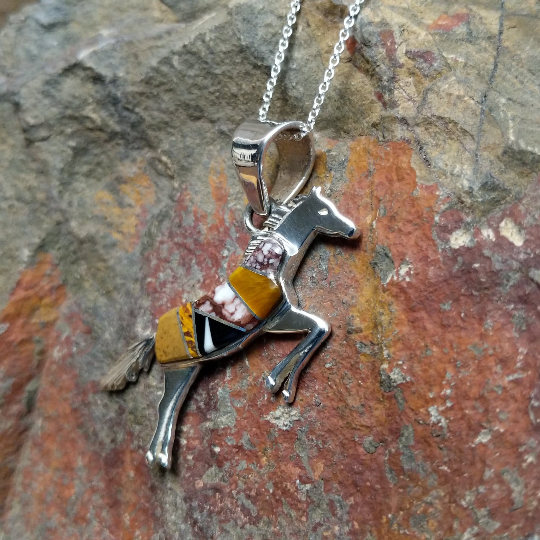 Handcrafted sterling silver multistone horse pendant by V.Y., featuring a traditional Navajo inlay horse design; side view.