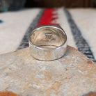 Navajo Multistone Inlay Ring by A.M.P. featuring a square geometric mosaic of turquoise, blue, purple, orange, red, and iridescent inlay set in a wide polished silver band; underside view.