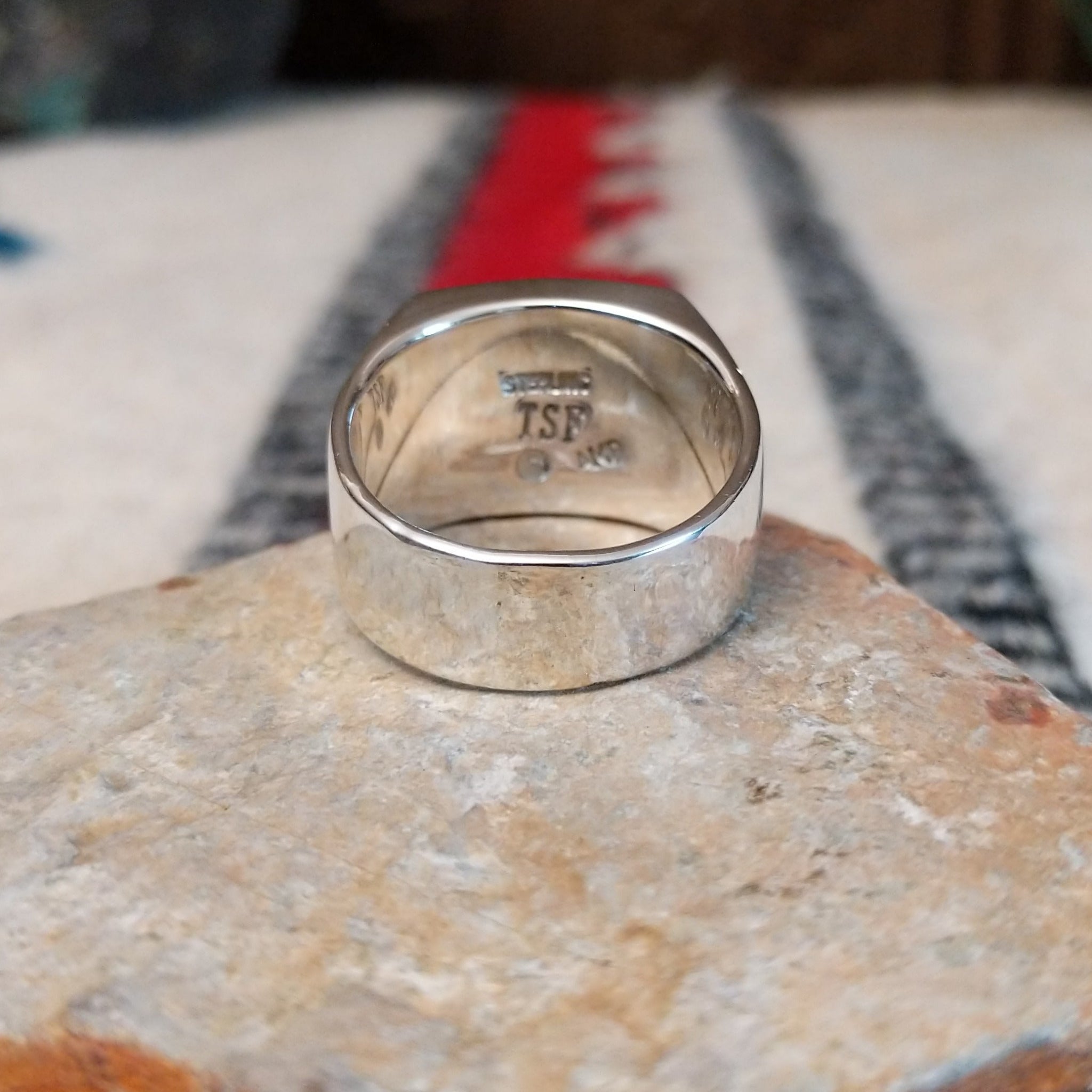 Navajo Multistone Inlay Ring by A.M.P. featuring a square geometric mosaic of turquoise, blue, purple, orange, red, and iridescent inlay set in a wide polished silver band; underside view.