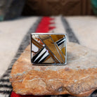 Navajo multistone inlay ring by B.J. with a square geometric design in brown, tan, black, and white stones separated by fine silver channels and set in polished silver.