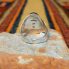 Navajo Multistone Inlay Ring by P.D. featuring an oval geometric mosaic of turquoise, black onyx, and contrasting stone inlays separated by thin silver dividers, set in a wide, polished silver band; underside view.