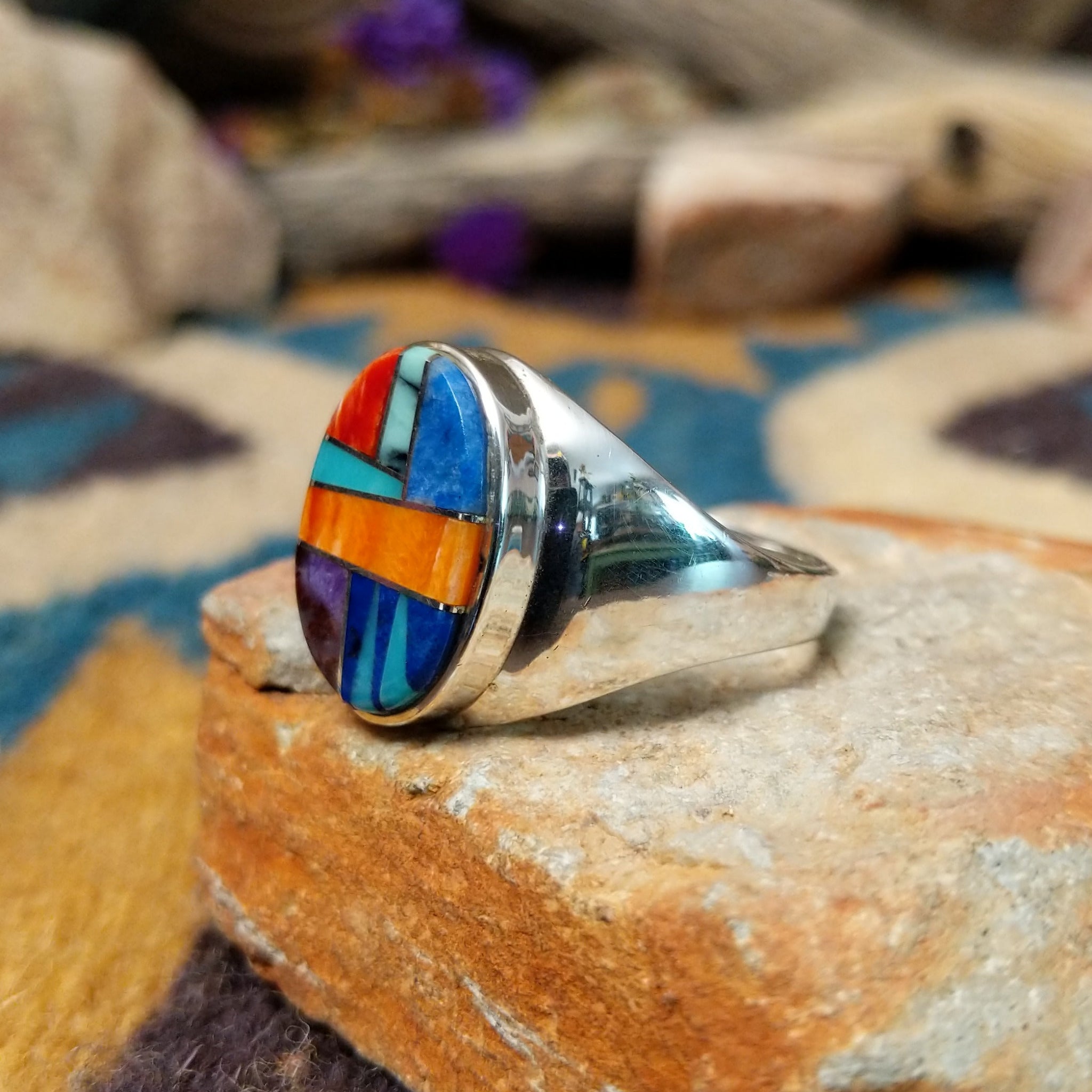 Sterling silver Navajo multistone inlay ring by P.D. featuring turquoise, red and orange spiny oyster shell, lapis, and geometric Southwestern inlay design; side view.