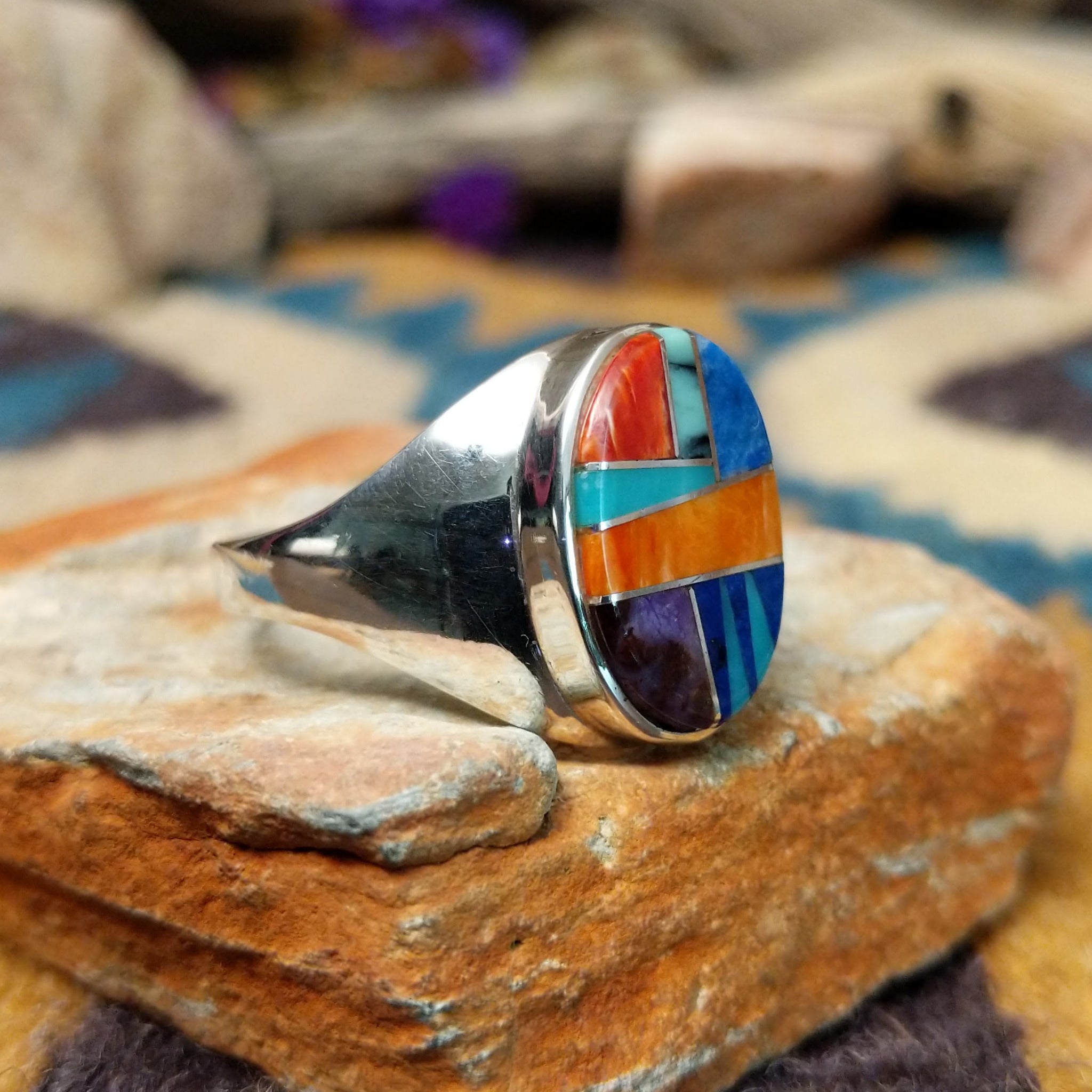 Sterling silver Navajo multistone inlay ring by P.D. featuring turquoise, red and orange spiny oyster shell, lapis, and geometric Southwestern inlay design; side view.