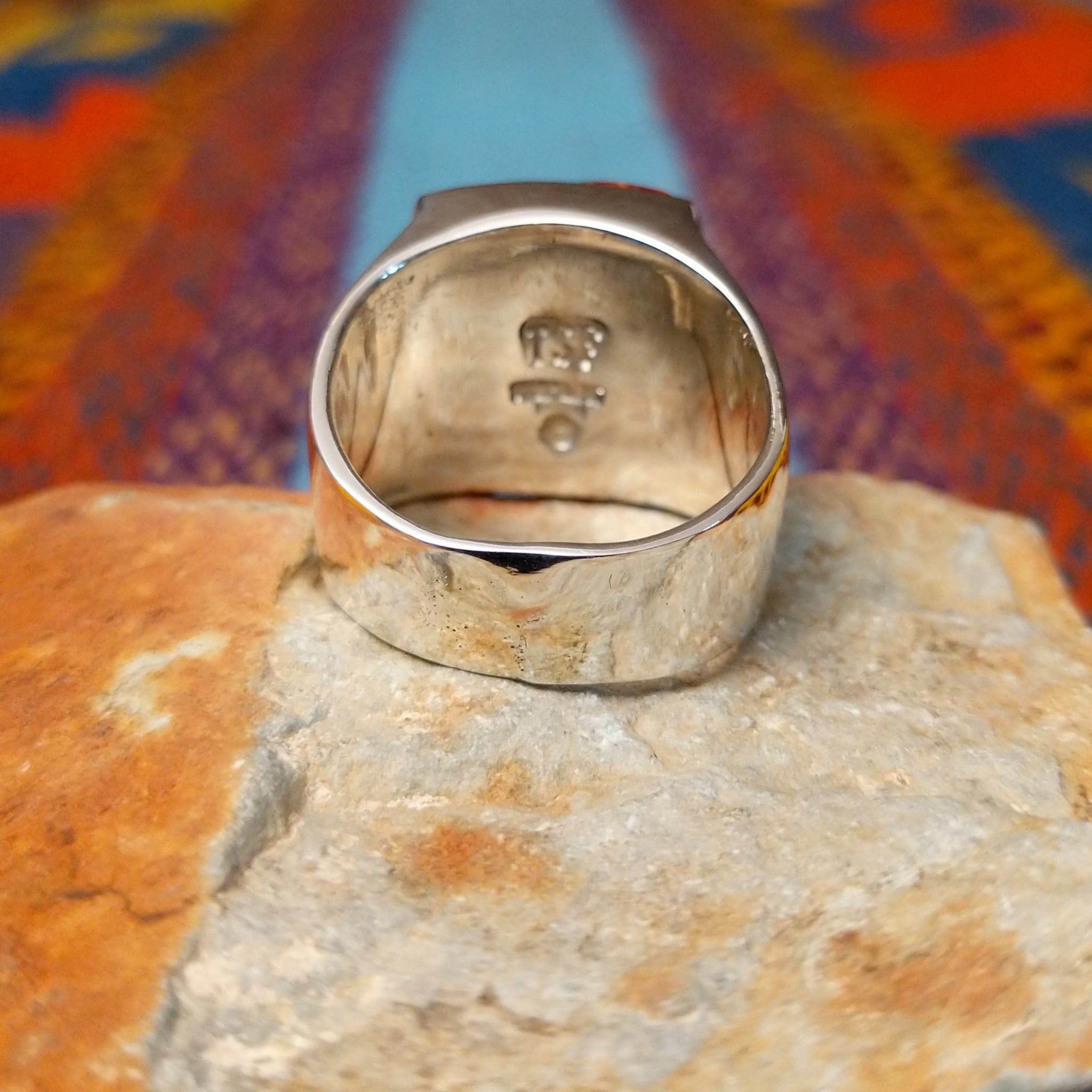 Navajo Multistone Inlay Ring by R.L. featuring geometric turquoise, lapis, and orange and red-toned spiney oyster shell inlay separated by Sterling Silver channels on a polished silver band; underside view.