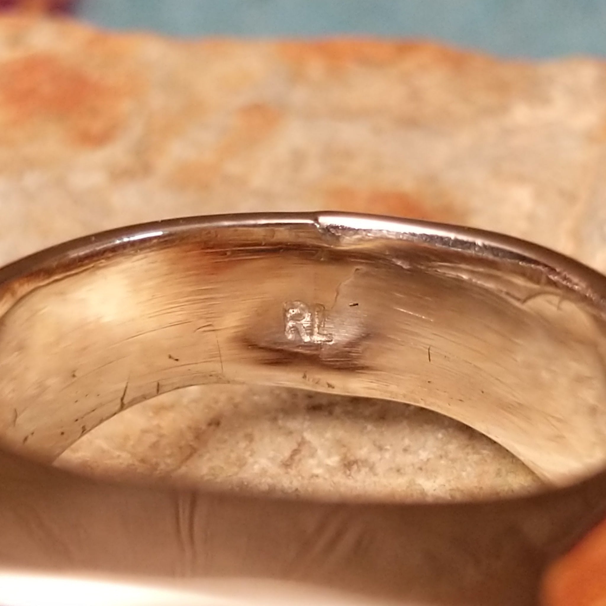 Navajo Multistone Inlay Ring by R.L. featuring geometric turquoise, lapis, and orange and red-toned spiney oyster shell inlay separated by Sterling Silver channels on a polished silver band; artisan stamp.